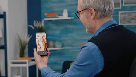 Elderly-remote-man-having-video-call-with-nephew-using-smartphone