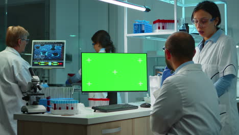 Team-of-microbiologists-researching-using-computer-with-green-screen
