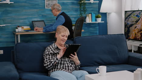 Happy-old-senior-grandmother-holding-digital-tablet-browsing-informations