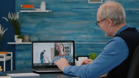 Glücklicher-älterer-Mann-Winkt-Während-Einer-Videokonferenz-Mit-Neffen,-Die-Einen-Laptop-Benutzen