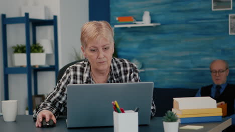 Old-middle-aged-businesswoman-working-at-laptop-from-home