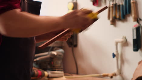 Carpenter-doing-woodworking-sandering-on-lumber-block,-fixing-damages