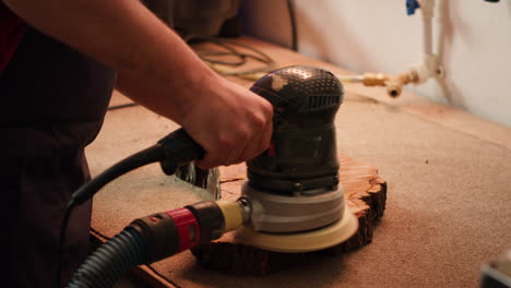 Carpenter-using-angle-grinder-on-timber-block-to-smooth-surfaces-with-sandpaper
