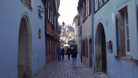 Tourists-walking-around-small-streets-with-gobblestone-roads-in-Colmar,-France