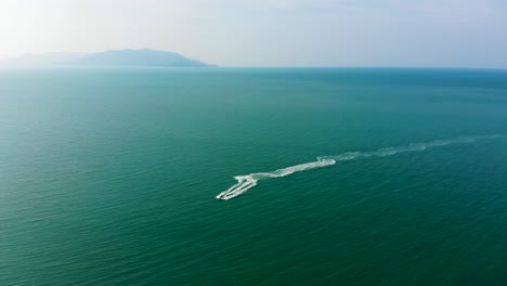 Drone-shot-of-a-jetski-rider-zigzagging-in-the-waters-of-the-Gulf-of-Thailand,-in-Koh-Samui-island,-Surat-Thani-province,-in-the-south-of-Thailand