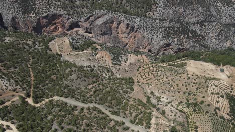 Vista-De-Drones-Cañón-Gigante-Formado-Entre-Dos-Grandes-Montañas,-Colinas-Montañosas-Con-Tierras-Agrícolas