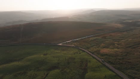 Cars-driving-on-epic-country-road-at-sunset,-drone-footage,-summer