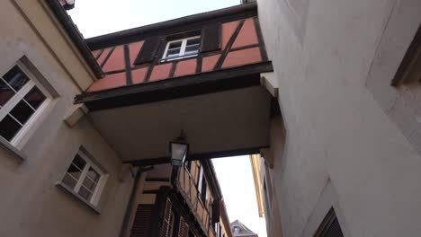 Half-timbered-architectural-building-with-Skybridge-crossing-the-street-in-historic-medieval-town-in-France