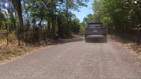 nissan-x-trail-driving-on-street-between-trees,compact-crossover-SUV,-gravel-street