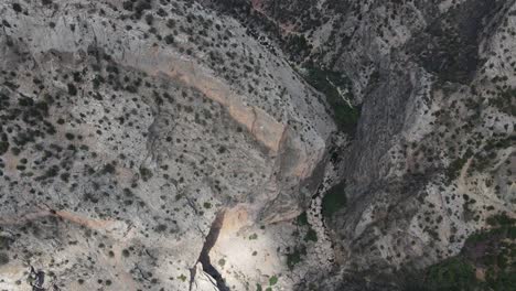 Drone-shot-of-the-giant-canyon-formed-between-two-large-mountains,-forest-view