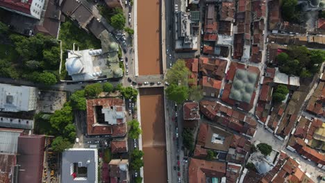 Drone-view-of-the-river-open-to-traffic-passing-through-the-middle-of-the-Bosnian-city,-aerial-drone-view-of-the-historical-old-town-hall