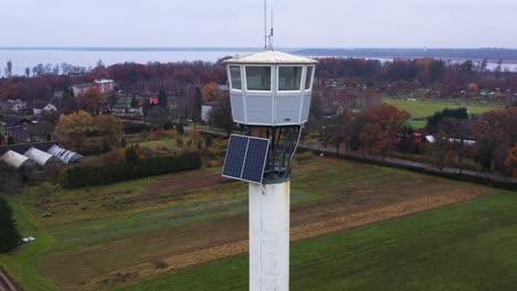 Old-fire-lookout-tower-with-solar-panels,-parallax-drone-view
