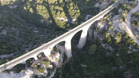 Drone-view-of-the-bridge-between-two-mountains,-an-old-historical-bridge