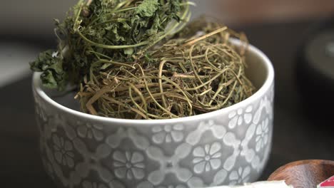 Kerala-leaves-in-bowl-on-table-Cerasee-bitter-melon-plant-with-kerala-hanging-from-vines-used-to-make-herbal-healthy-tea-good-for-weight-loss