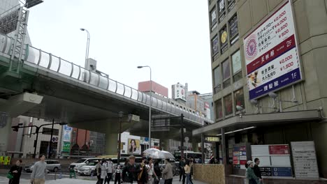 Blick-Auf-Die-Autobahnüberführung-über-Sennichimae-Dori-In-Namba,-Osaka,-Mit-Menschen,-Die-An-Einem-Bewölkten-Tag-Vorbeigehen