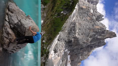 Vertikales-Video-Eines-Kaukasischen-Mannes,-Der-Auf-Einen-Felsen-Im-Lago-Di-Sorapiss-In-Den-Dolomiten-Klettert