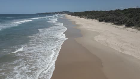 Aerial:-Waves-gently-lap-at-sand-beach-of-Warners-Bay,-NSW,-Australia
