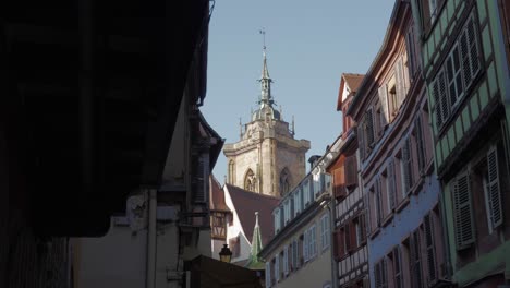 Scenic-view-of-the-cathedral-tower-behind-medieval-buildings-in-Colmar,-France