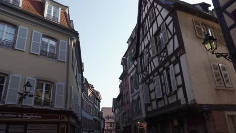 Beautiful-half-timbered-architectural-buildings-in-medieval-town-in-Colmar,-France-with-shops-on-ground-level
