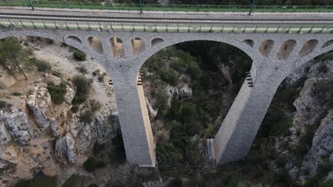 Aerial-view-from-a-drone-of-the-big-bridge-over-the-valley-formed-between-the-big-mountains