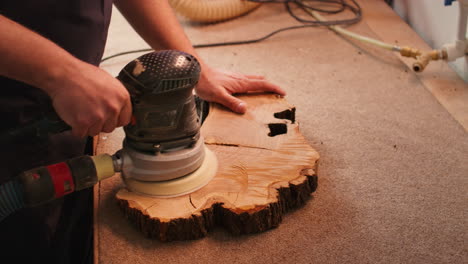 Woodworking-specialist-in-furniture-assembly-shop-using-angle-grinder