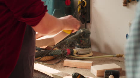 Coworking-artisans-in-studio-using-sandpaper-and-wood-shaper