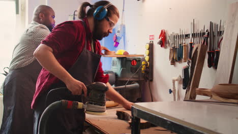 Artisan-with-protecting-equipment-uses-angle-grinder-on-wood