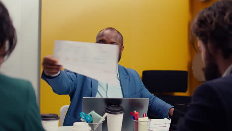 African-american-project-manager-providing-clipboard-with-important-information