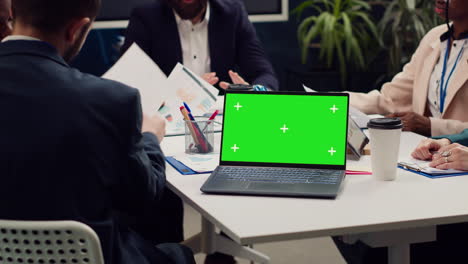 Business-partners-attending-meeting-next-to-greenscreen-laptop