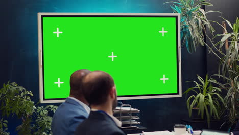 Startup-team-watching-an-ad-campaign-video-on-greenscreen-display,