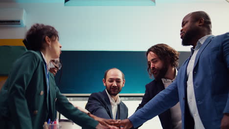 Startup-team-uniting-hands-together-to-celebrate-successful-project