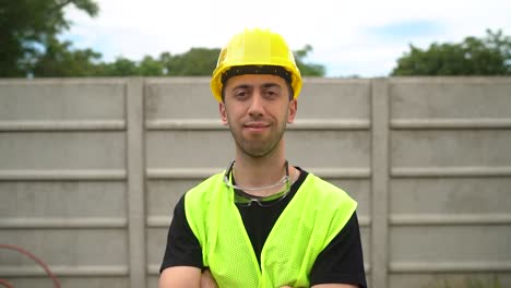 A-Construction-Worker,-Clad-in-a-Yellow-Hard-Hat,-Crosses-His-Arms-Over-His-Chest,-Expressing-Contentment-with-the-Completed-Job---Medium-Close-Up