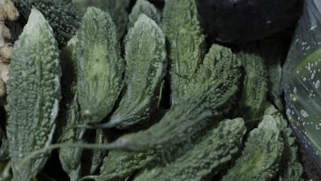 Verduras-Frescas-De-Calabaza-Amarga-En-La-Tienda-De-Verduras-A-La-Venta-Por-La-Noche