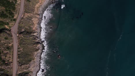 Aerial-drone-overhead-view-of-a-car-driving-on-Highway-1-near-Big-Sur,-California