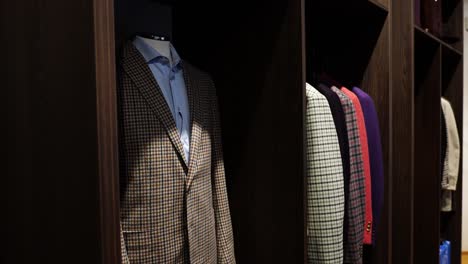 Handmade-plaid-suits-in-different-colors-organized-in-open-wood-closet