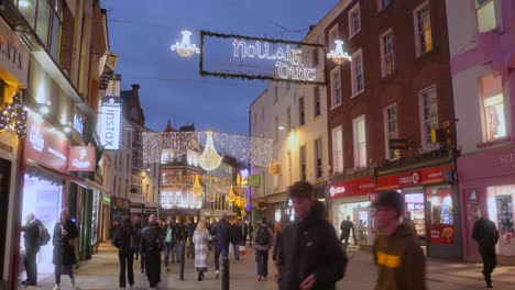 Tilt-down-establisher-Dublin-shopping-street-in-Christmas,-beautiful-decorations