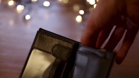 Polnisches-Bargeld-In-Die-Brieftasche-Stecken-Und-Herausnehmen,-Weihnachtsbeleuchtung-Im-Hintergrund,-Geschenke-Kaufen