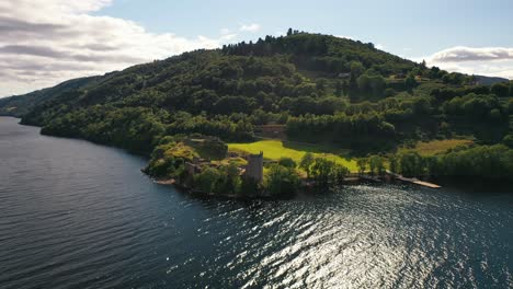 Stunning-Aerial-Pullback-Shot-of-Urquhart-Castle-over-Loch-Ness,-Scottish-Highlands,-Scottish-Landscape,-Scotland,-United-Kingdom
