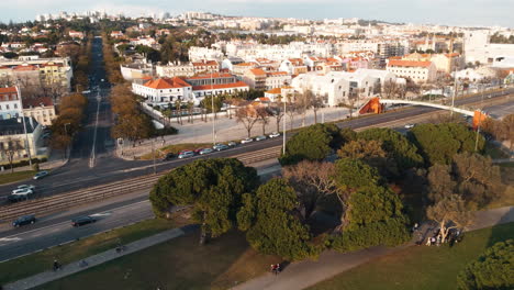Aerial-panning-shot-showing-Belem-Suburb-of-Lisbon-with-traffic-on-road-at-sunset-time,-Portugal