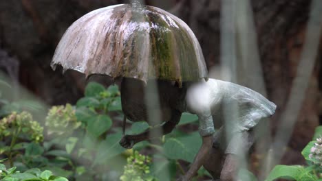 Kunstinstallation-Eines-Mädchens,-Das-Einen-Regenschirm-Im-Regen-In-Den-Gärten-An-Der-Bucht-In-Singapur-Hält