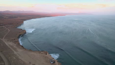 Aerial-drone-shot-of-vehicles-camping-on-the-coast-of-Baja-Mexico-near-a-surf-break