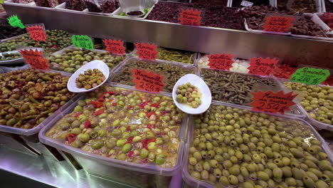A-food-stand-with-all-kinds-of-olives-at-a-market-in-Malaga,-Spain