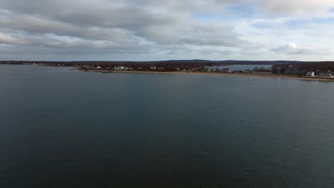 An-aerial-view-of-the-calm-waters-of-the-Long-Island-Sound-off-Southold-Town-Beach-on-Long-Island,-NY-on-a-cloudy-day
