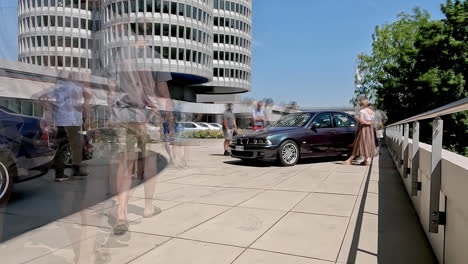 People-admires-old-shinny-BMW-cars-near-Munich-museum,-time-lapse