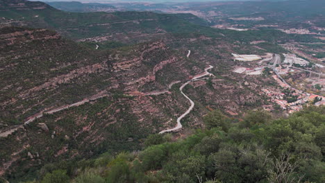 Drone-reveal-shot-gliding-over-green-cliffs-of-Grand-Canyon-of-Spain-on-tranquil-overcast-day