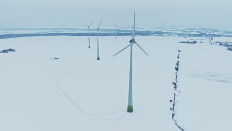 Luftaufnahme-Eines-Windmühlenparks,-Die-Rotorblätter-Drehen-Sich-Und-Produzieren-Strom-Für-Verbraucher