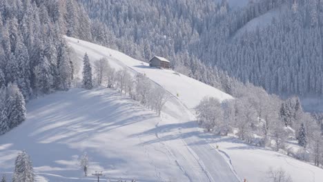 Kleine-Hütte-Neben-Einer-Skipiste-In-Österreich,-Bedeckt-Mit-Schnee