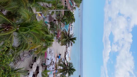Vertical-dorne-shot-approaching-beach-of-Boca-Chica-in-Santo-Domingo,-Dominican-Republic