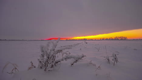 Snowy-frozen-ground-sky-clouds-moving-time-lapse-revealing-orange-sky-at-sunrise