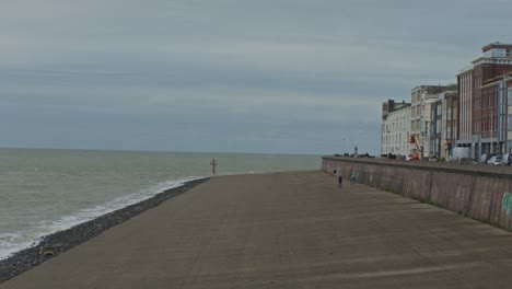 ocean-sea-water-and-houses-buildings-near-seafront-shore-with-cloudy-eather-and-grey-skies-in-a-cinematic-footage